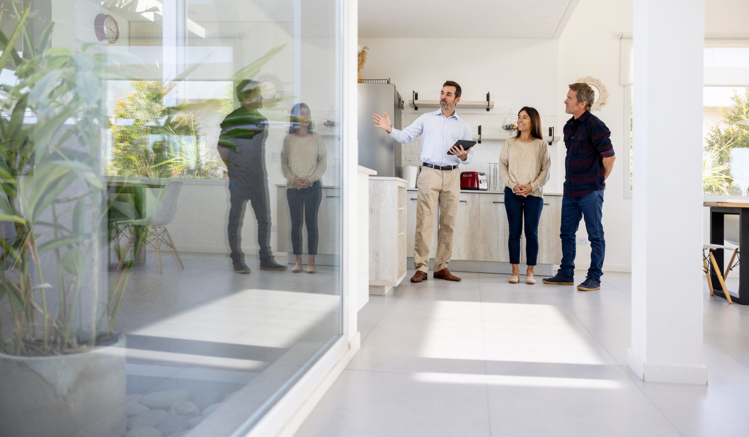 Real estate agent showing a house for sale to a couple