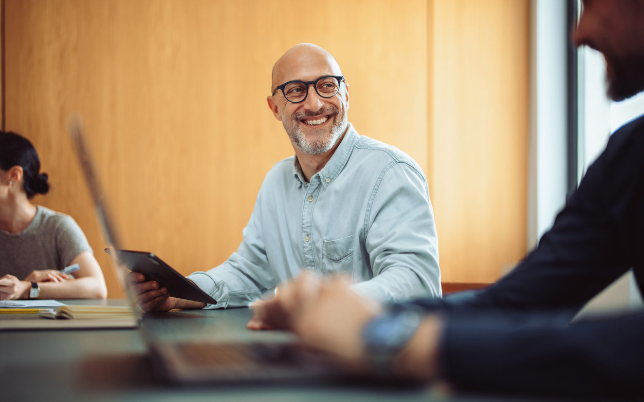 Smiling Businessman in Team Meeting with Colleagues in Office
